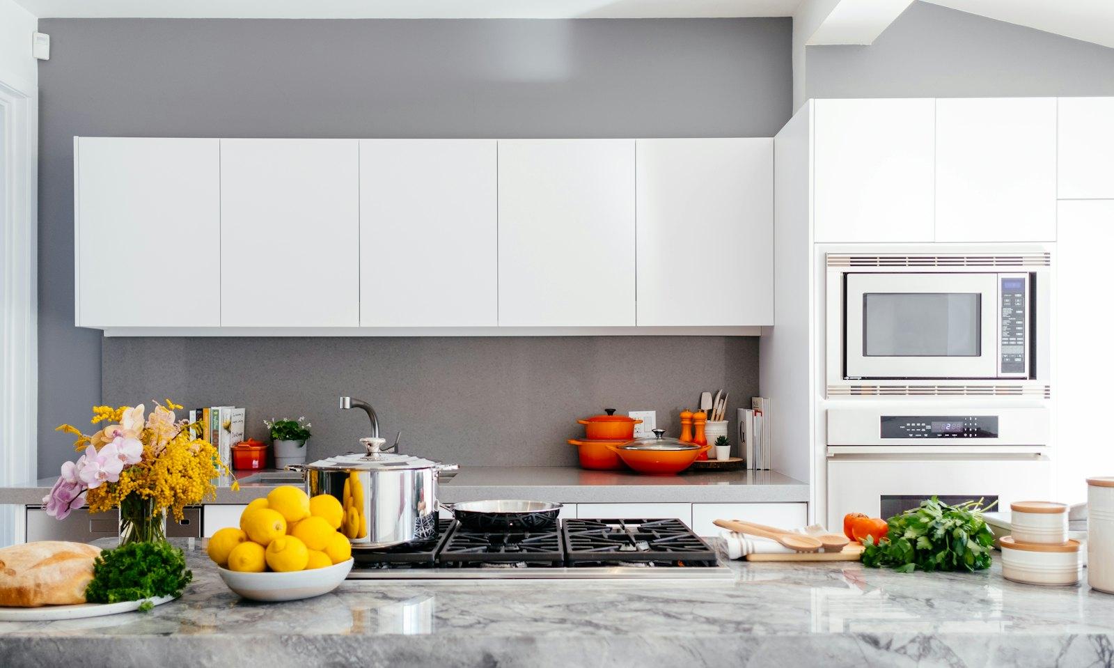 Finished kitchen remodel with white cabinetry and a stone island