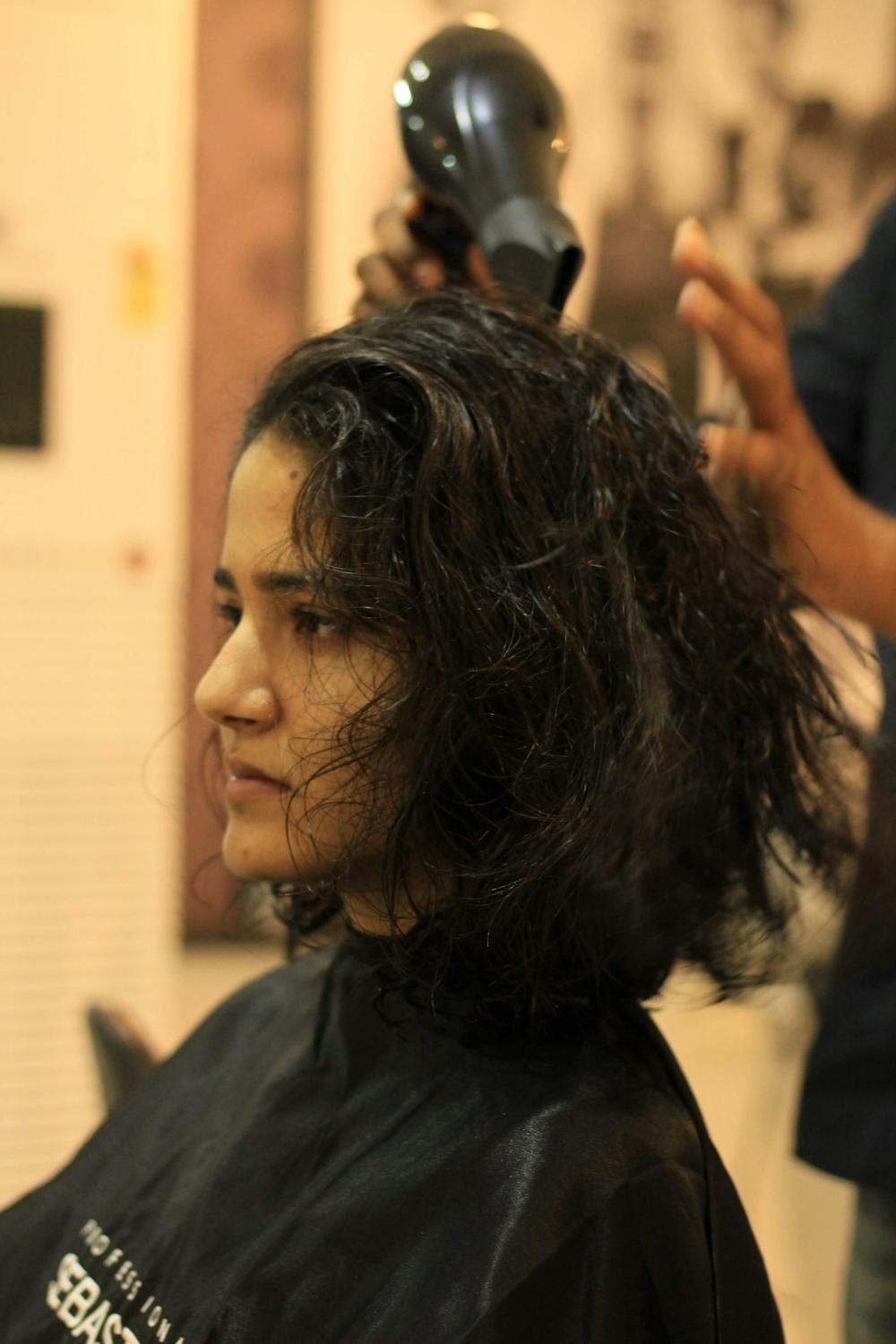 A stylist finishing a client's cut