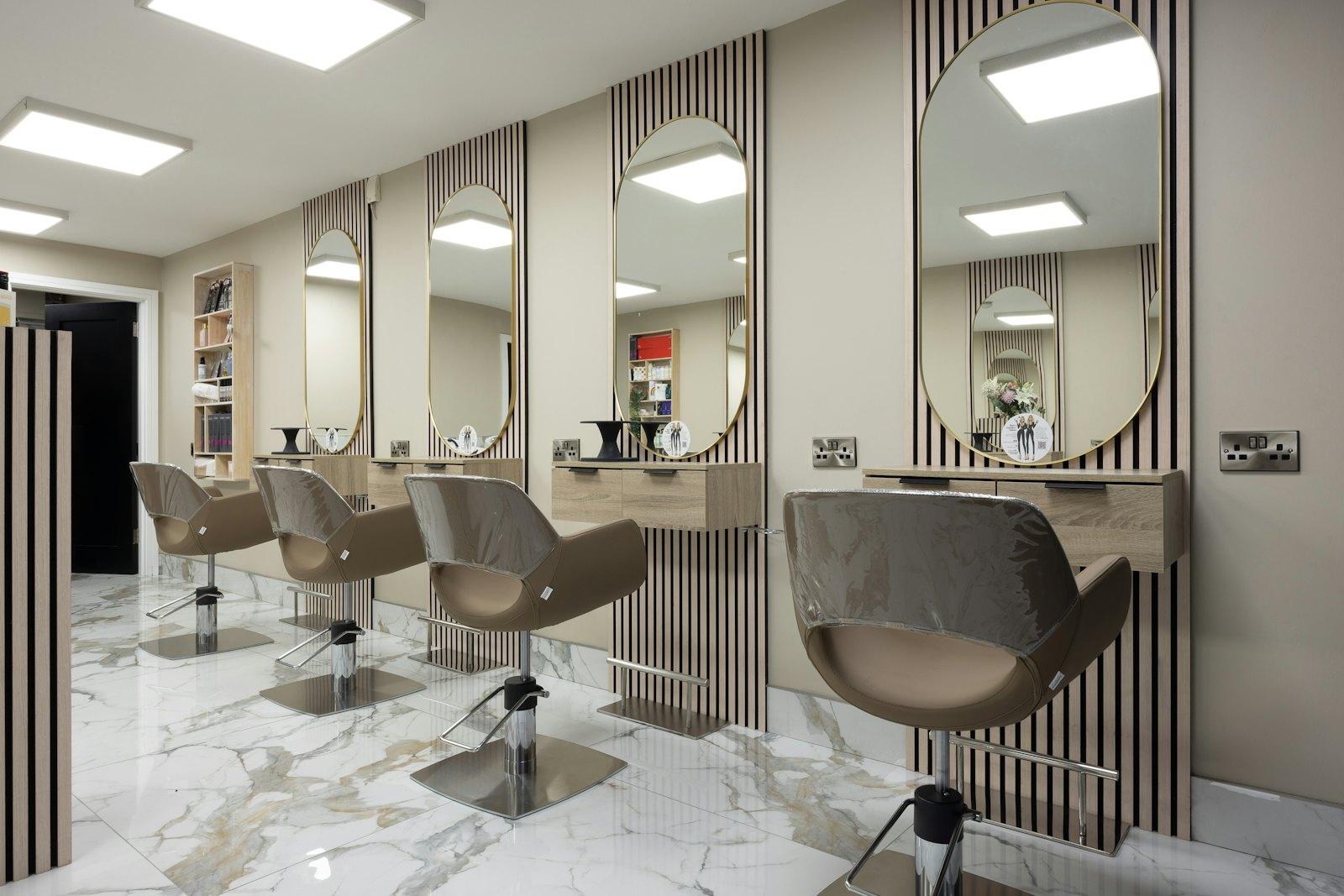 Styling stations with marble walls and brass mirrors